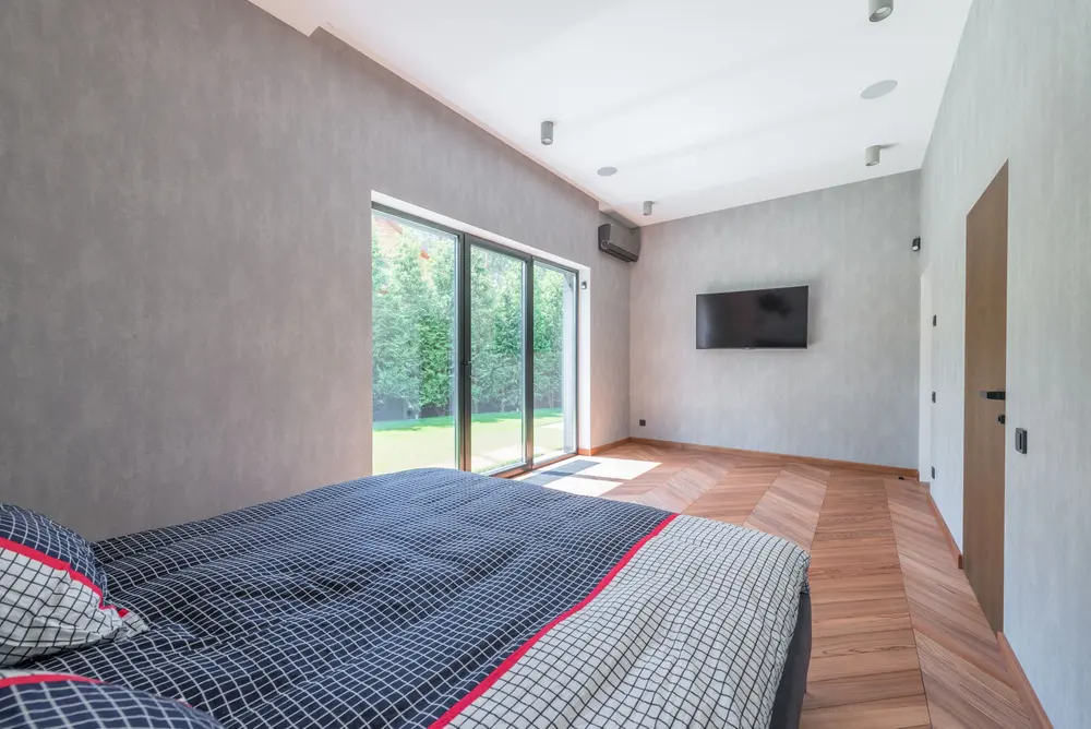 Laminate flooring — bright cozy minimalist bedroom large sliding glass — Laminate Flooring by OC Floor Guy