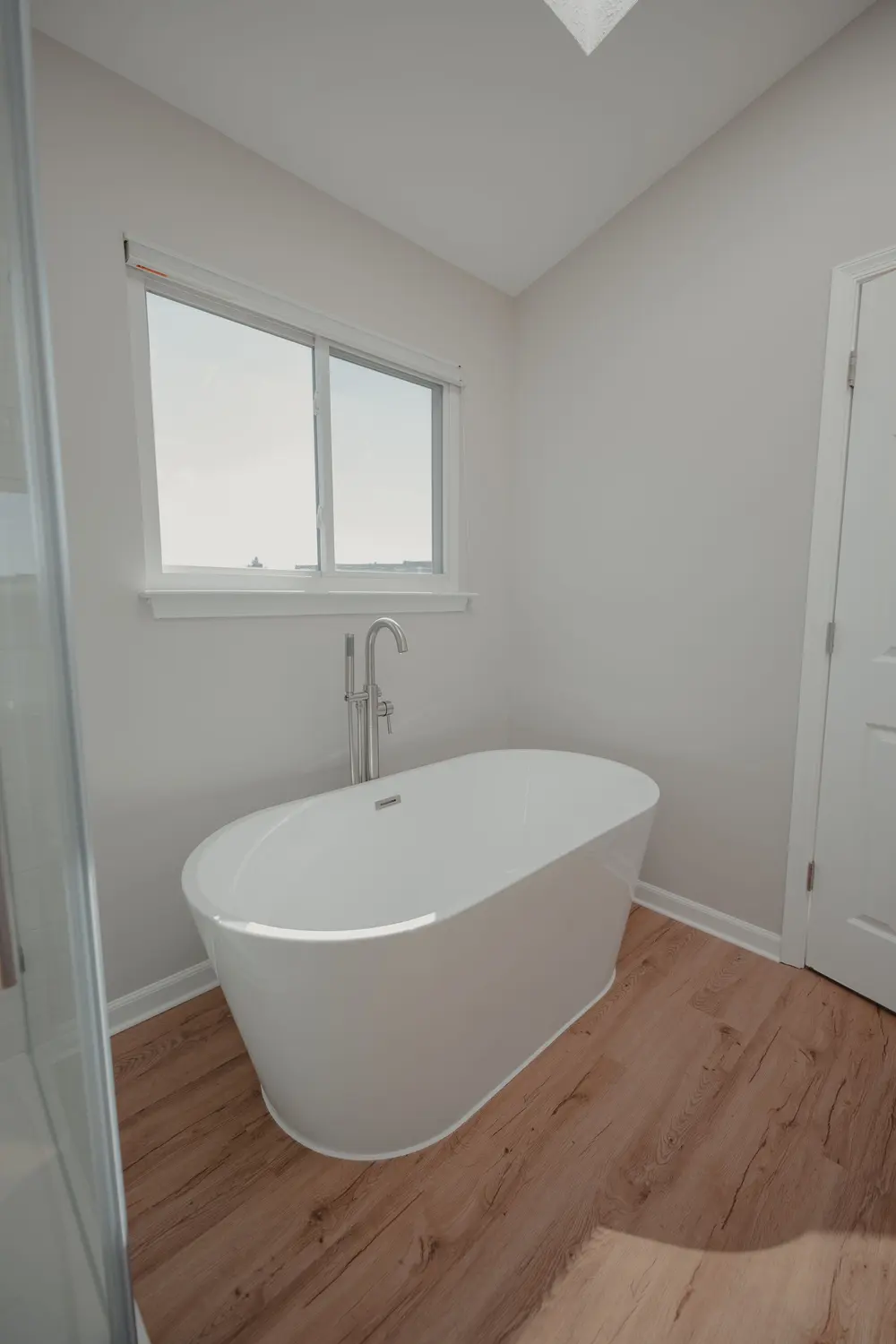 Luxury vinyl plank flooring — bright airy bathroom sleek freestandi — near Seal Beach, CA