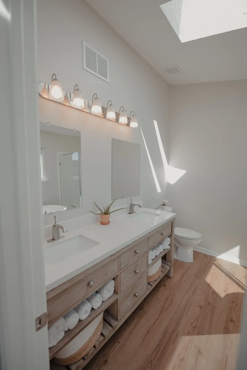 Luxury vinyl plank flooring — bright minimalist bathroom double van — near Orange, CA